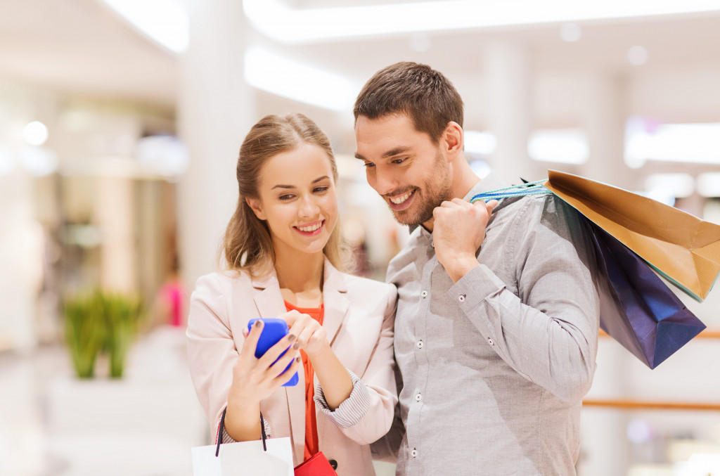 couple looking at a smartphone while shopping inside a mall