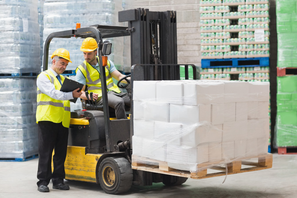 Forklift driver with other employee in a warehouse